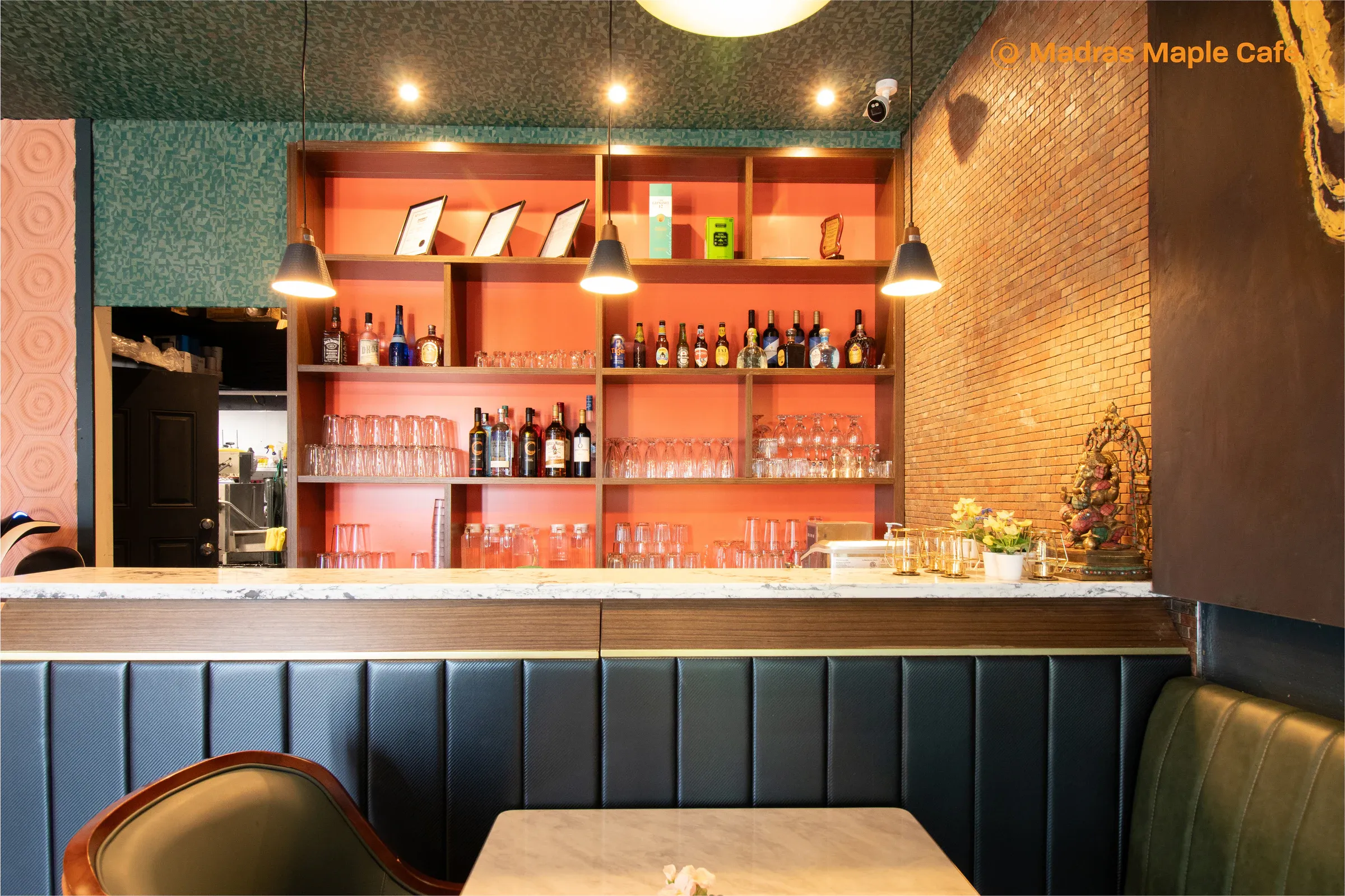 The Madras Maple Cafe bar with warm coral shelving and dark paneling